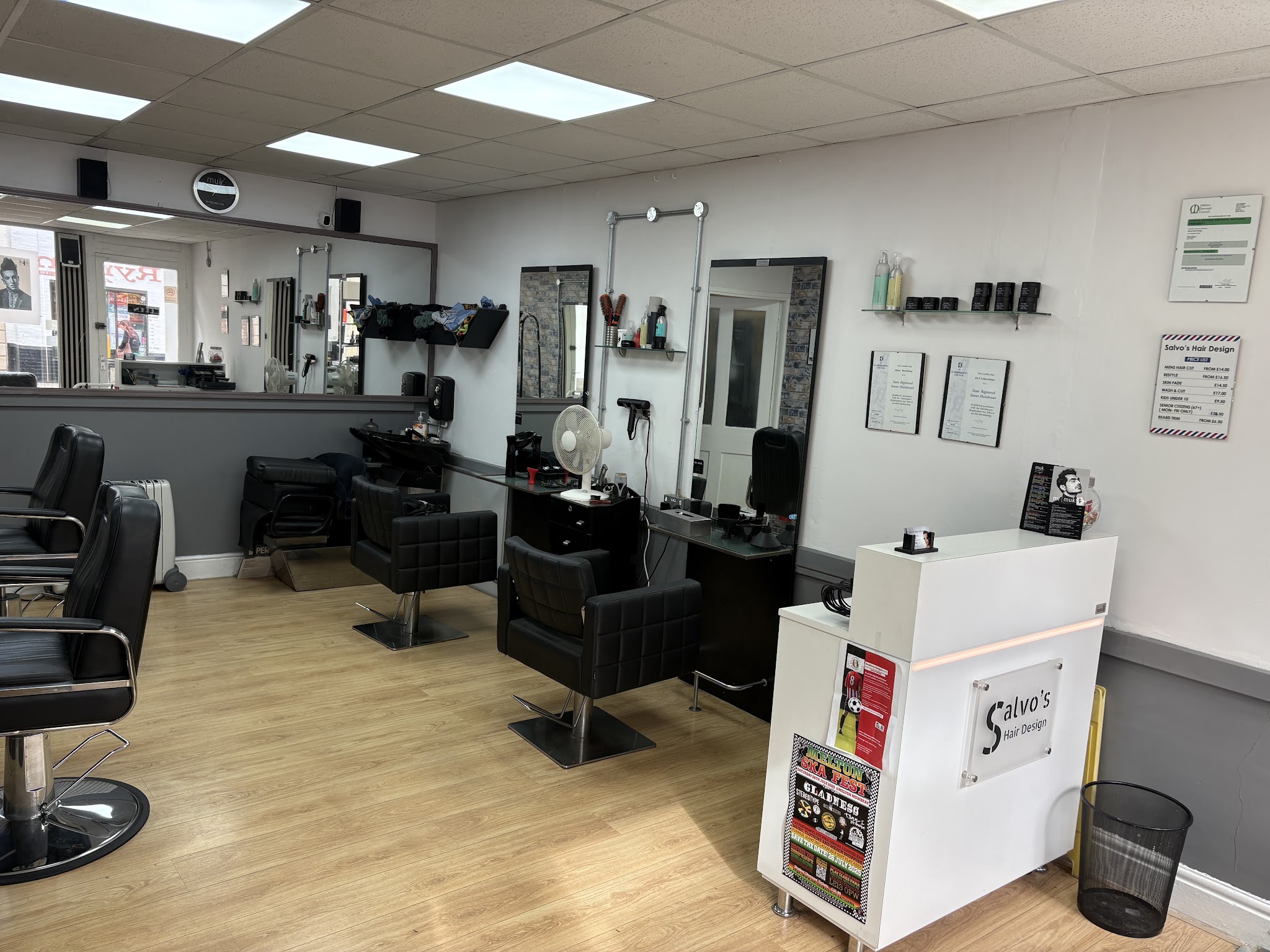 The barber chairs, mirrors and white reception desk at Salvo's Hair Design