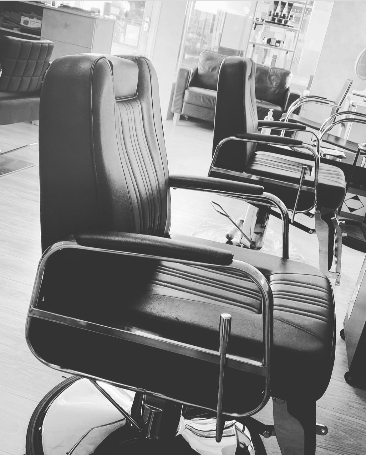 Black and white close-up of a black leather barber chair at Salvo's